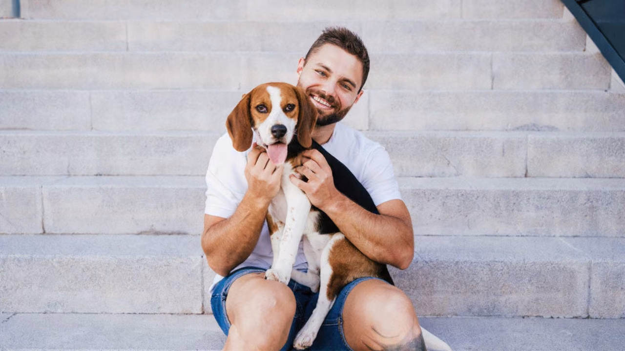 Man hugging his beagle on stone steps, ESA letter in New York
