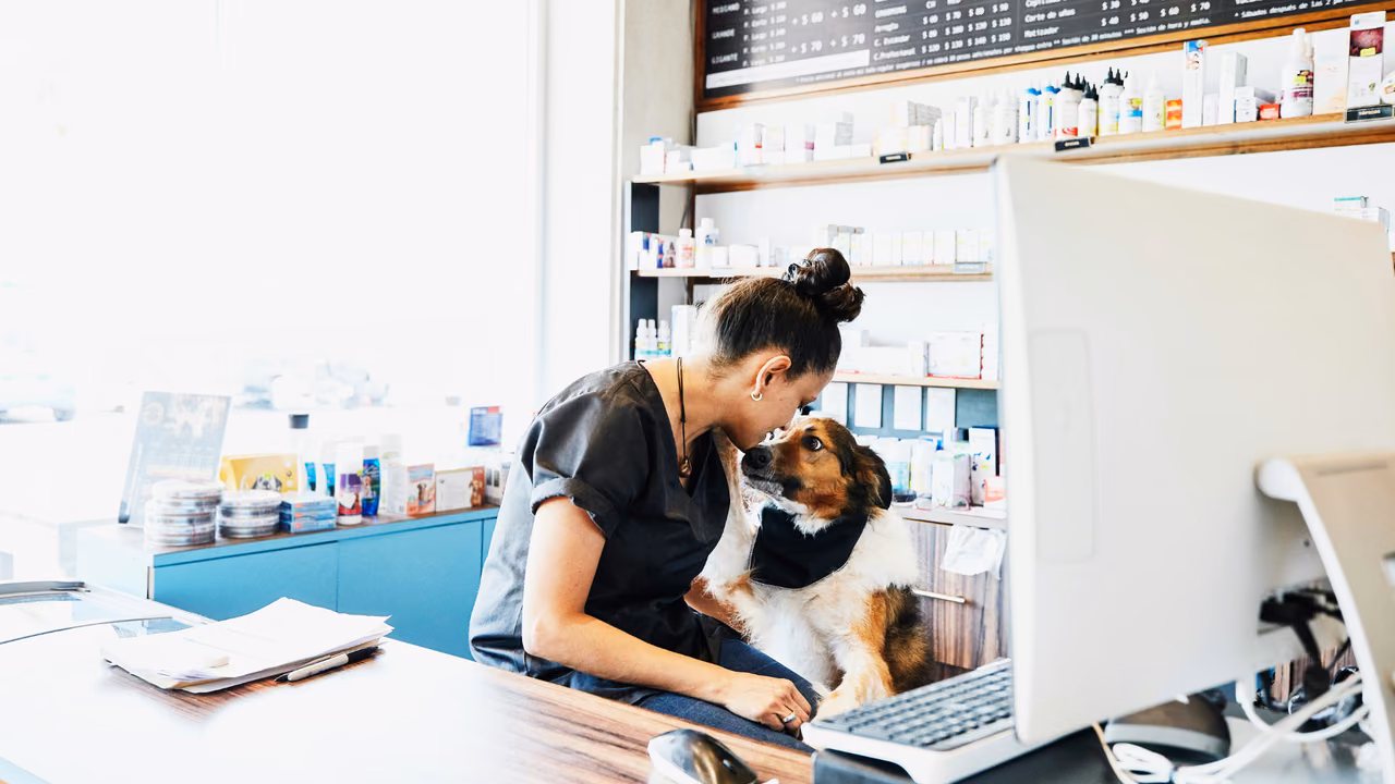 Vet tech with a small dog at a clinic front desk, ESA letter in Newark, NJ