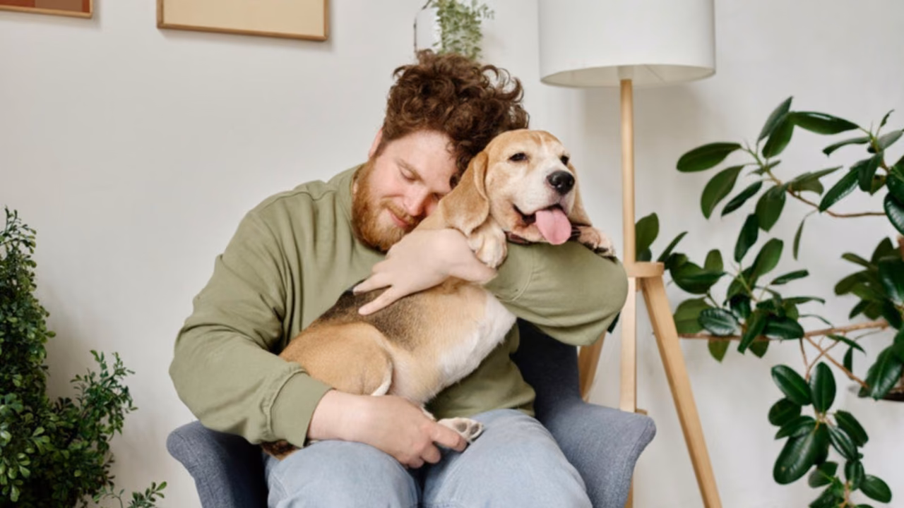 Man hugging his dog in an armchair at home, ESA letter in North Dakota