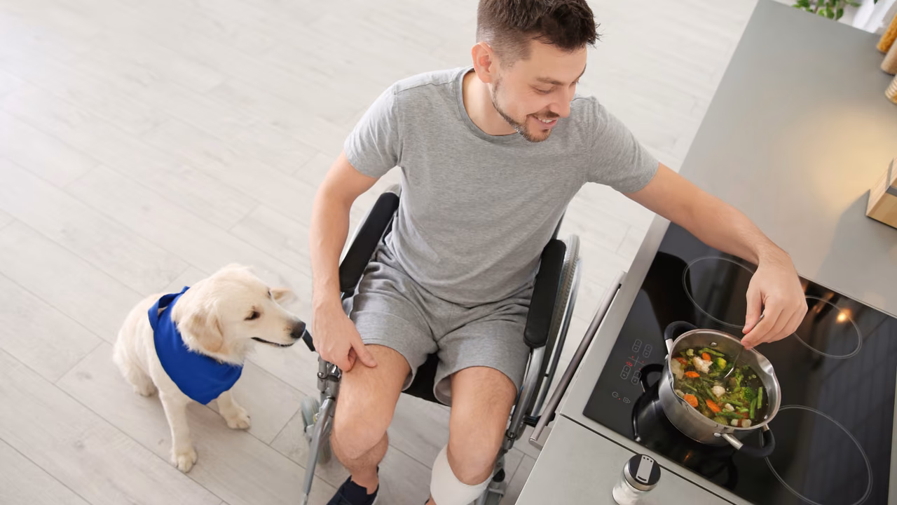 Man in a wheelchair cooking with his dog beside him, PSD letter in Mississippi